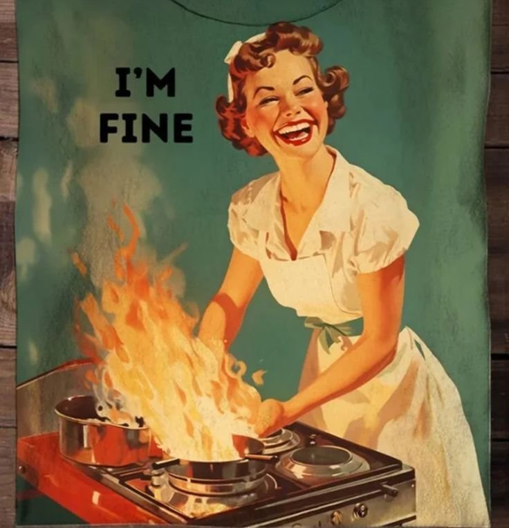 A smiling woman cooking over a pan in flames: I'm fine